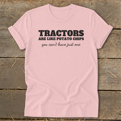 Pink t-shirt with black text that reads "TRACTORS are like potato chips you can't have just one."
