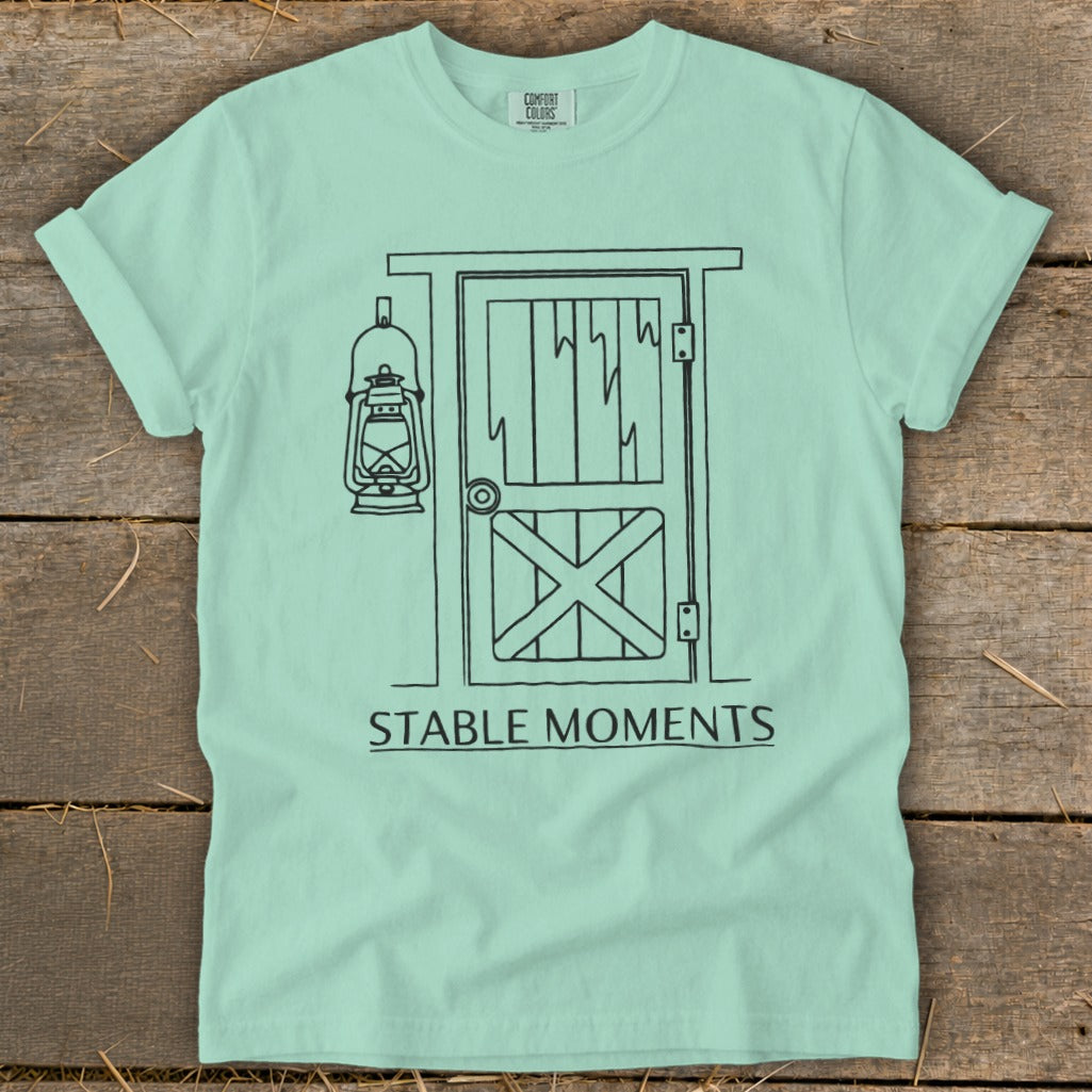 Mint green t-shirt with a line drawing of a stable door and lantern, text "STABLE MOMENTS."