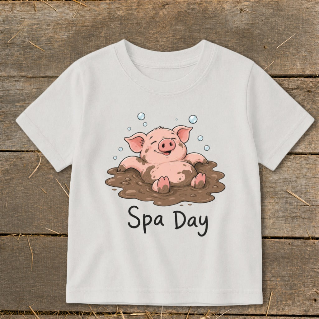 White t-shirt with cartoon pig relaxing in mud, text "Spa Day"