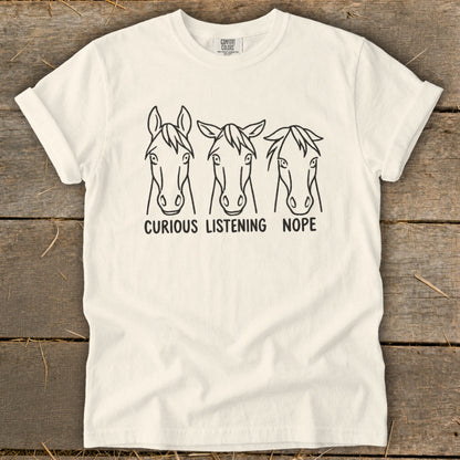 Off-white t-shirt featuring three horse face line drawings with the text curious listening nope underneath.