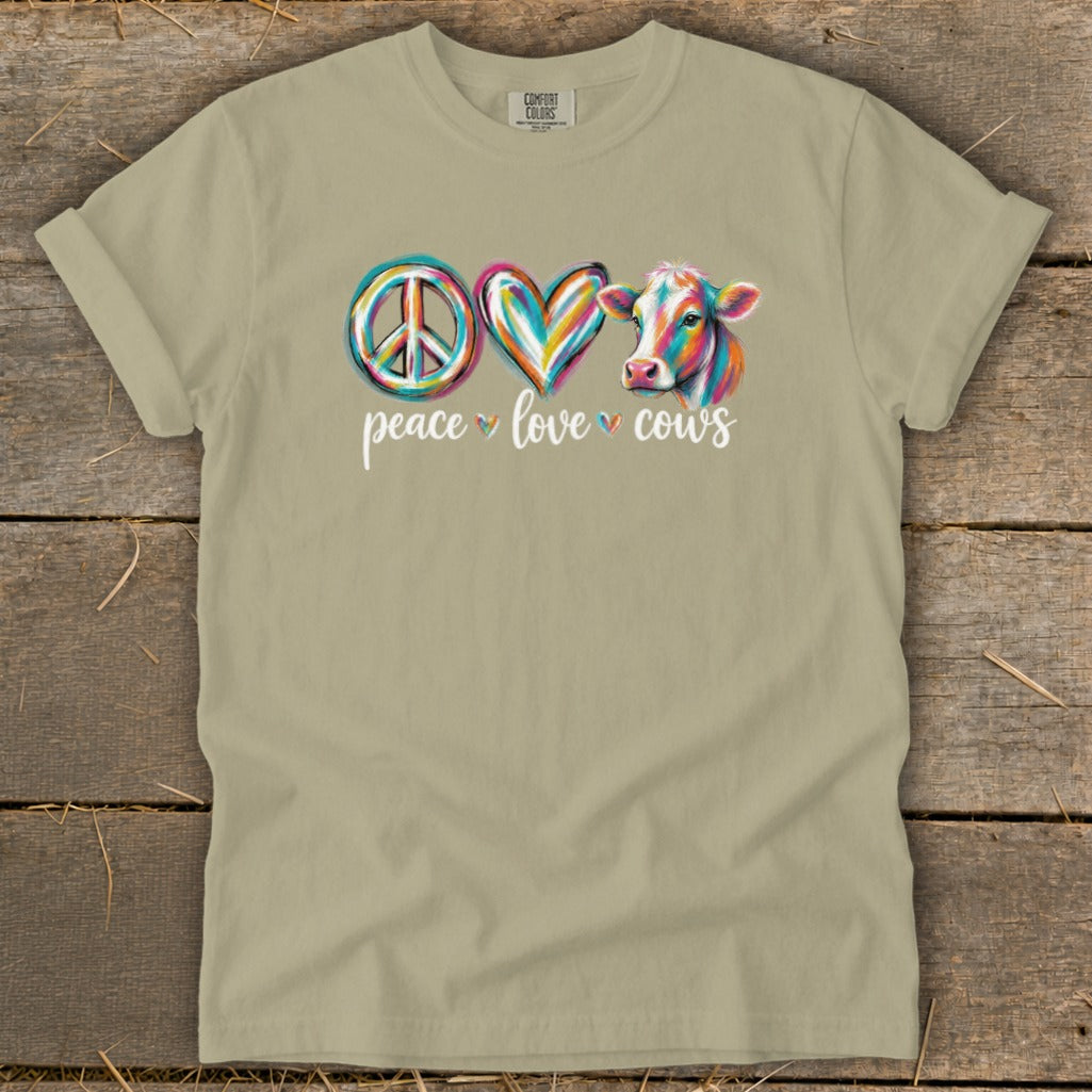 Peace Love Cows graphic on a tan t-shirt with watercolor cow and text.