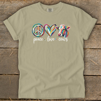 Peace Love Cows graphic on a tan t-shirt with watercolor cow and text.