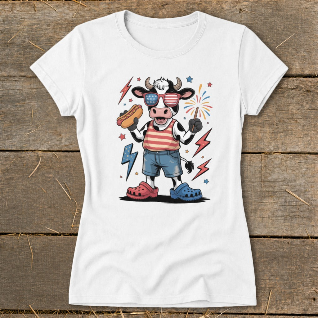 Cartoon cow in sunglasses holding hot dog, wearing red, white, and blue.
