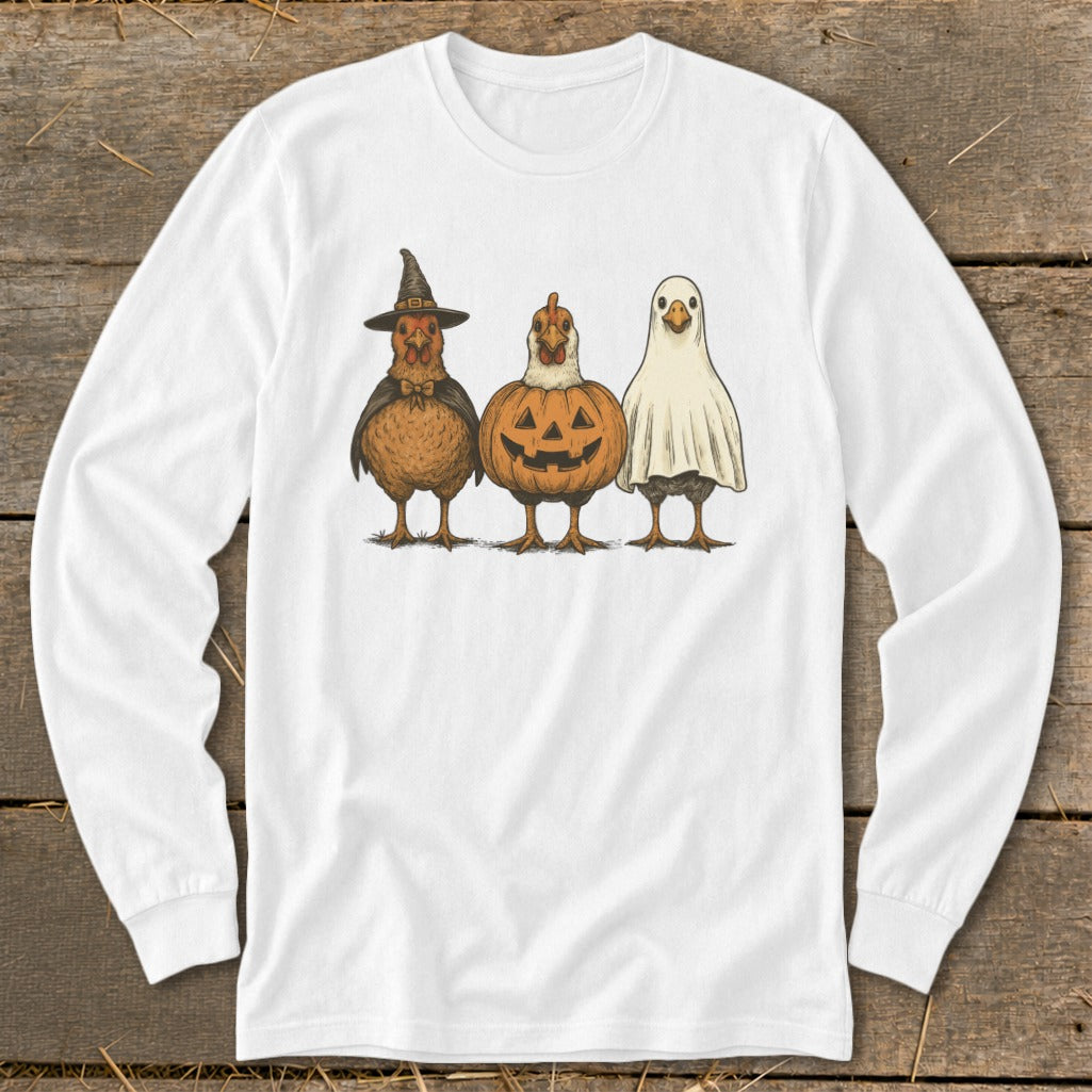 Three chickens dressed for Halloween: witch, pumpkin, and ghost costumes on white long-sleeve shirt.