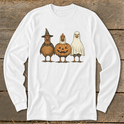 Three chickens dressed for Halloween: witch, pumpkin, and ghost costumes on white long-sleeve shirt.
