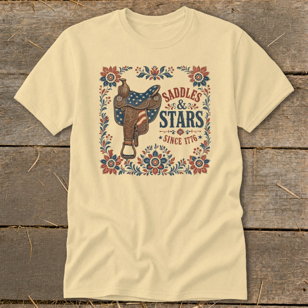 Cream t-shirt with a patriotic saddle design and "Saddles & Stars Since 1776" text.