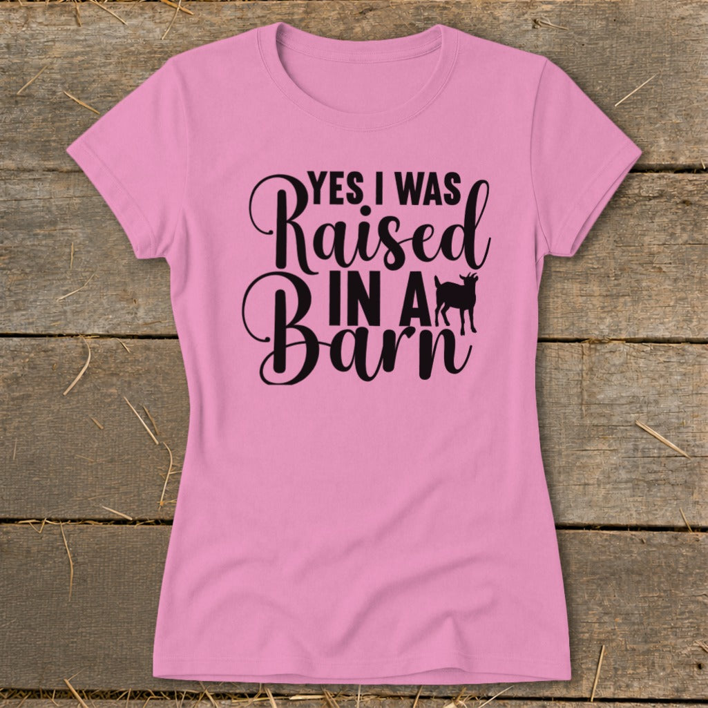 Pink t-shirt with black text reading "YES I WAS Raised IN A Barn" and a goat silhouette.