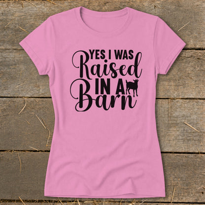 Pink t-shirt with black text reading "YES I WAS Raised IN A Barn" and a goat silhouette.
