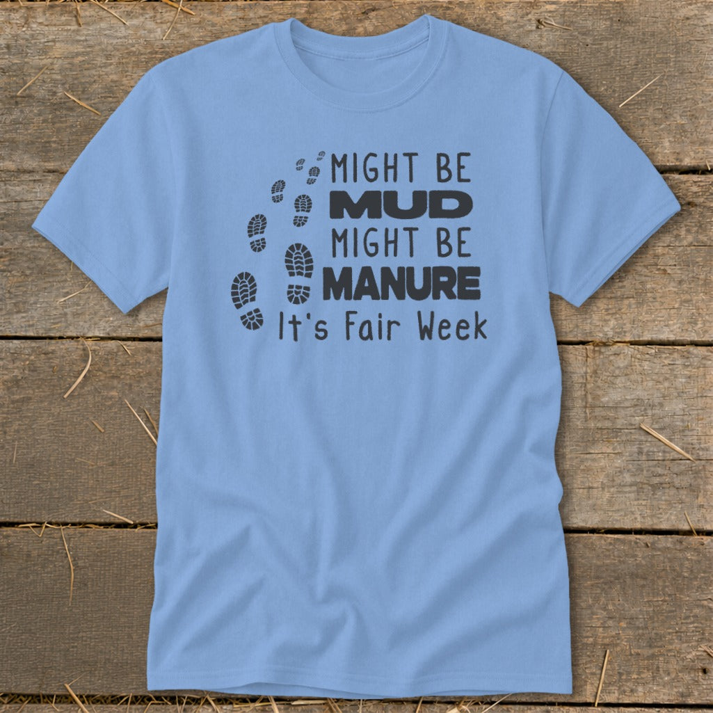 Light blue t-shirt with black text and footprints saying "Might be Mud, Might be Manure, It's Fair Week."