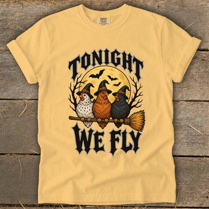 Three chickens wearing witch hats sit on a broom with the words "Tonight We Fly."