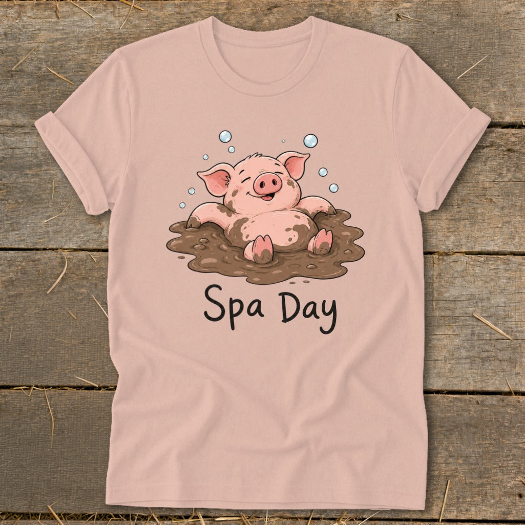 Pink t-shirt with illustration of a happy pig in mud with "Spa Day" text.