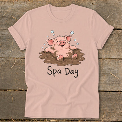 Pink t-shirt with illustration of a happy pig in mud with "Spa Day" text.