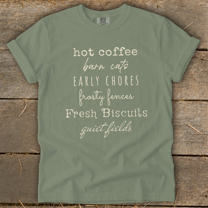 Sage t-shirt with list of phrases: hot coffee, barn cats, early chores, frosty fences, Fresh Biscuits, quiet fields.