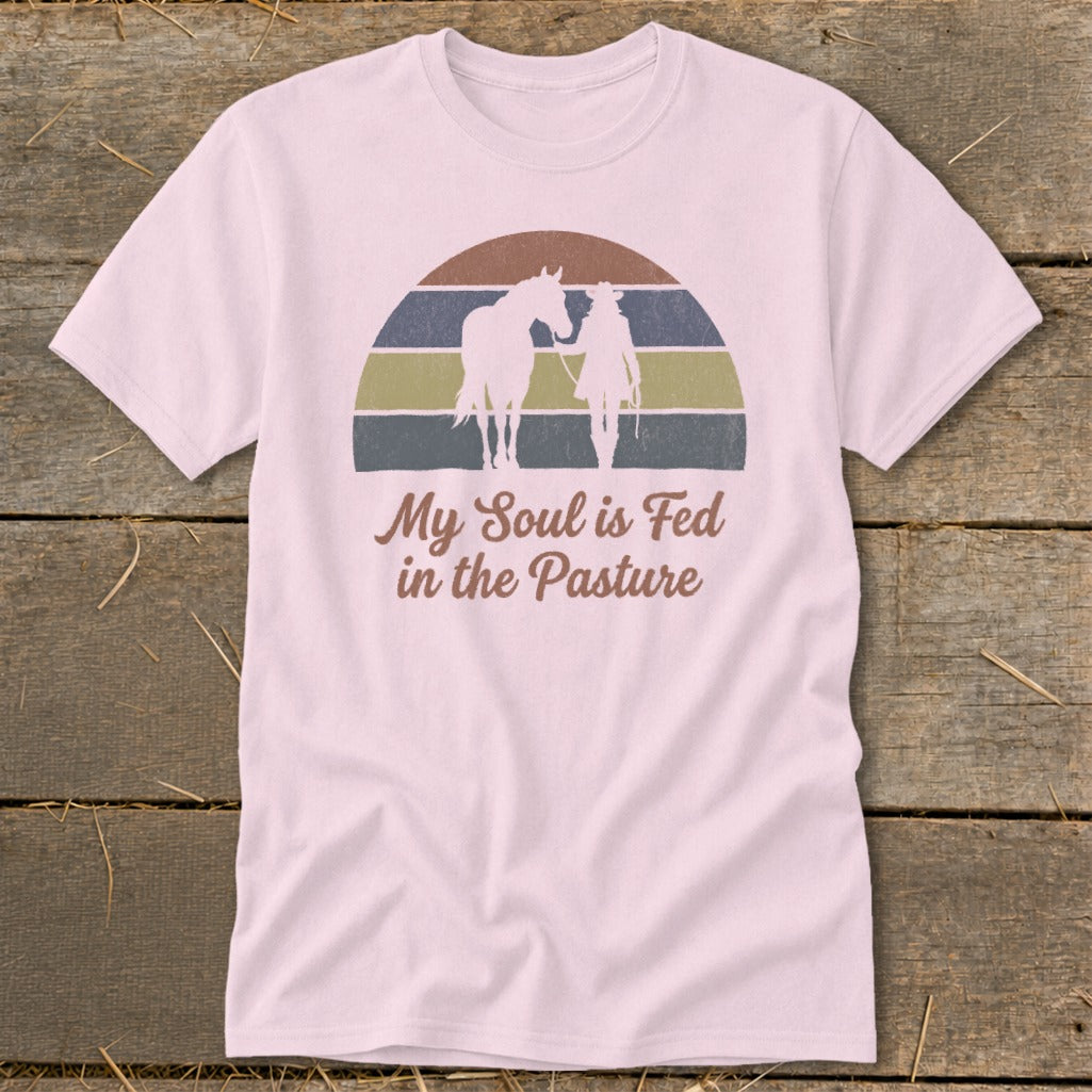 Pink t-shirt with silhouette of person and horse, "My Soul is Fed in the Pasture" text.
