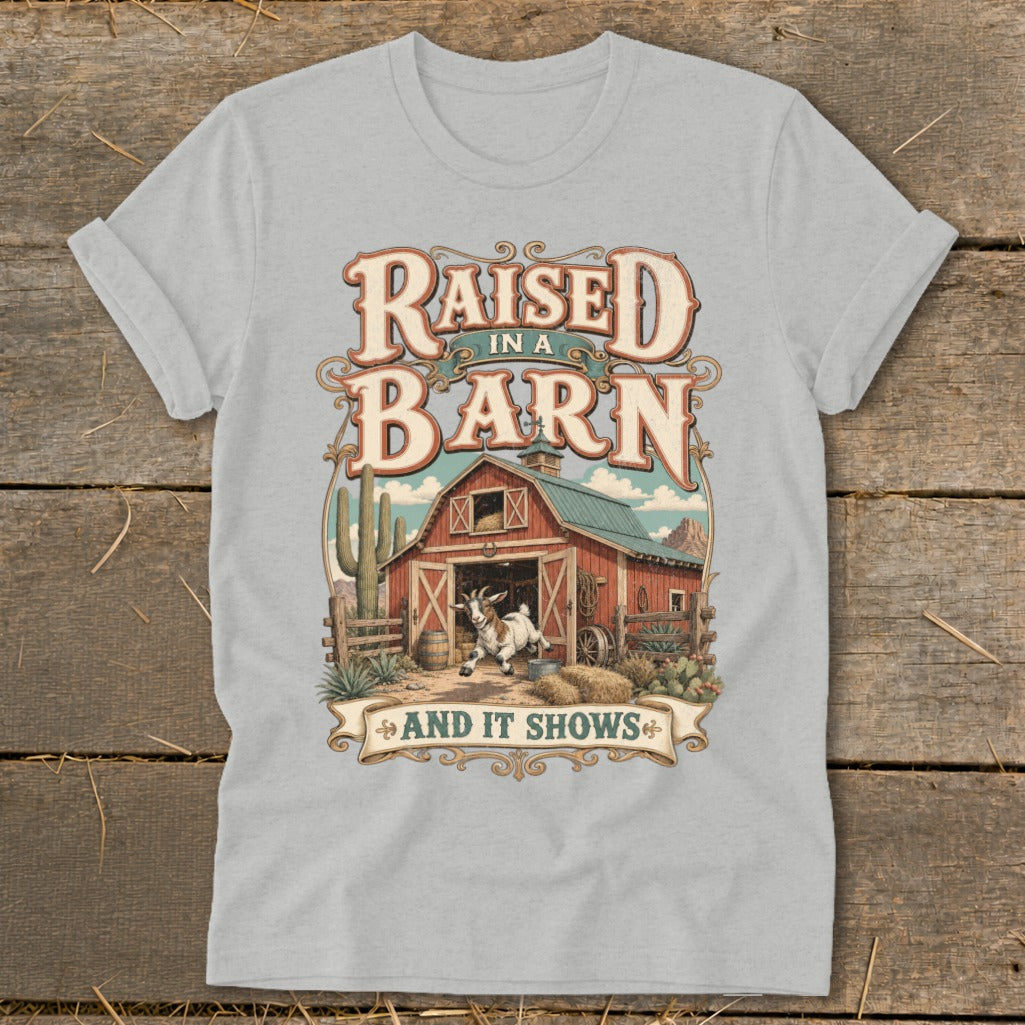 T-shirt graphic with text "Raised in a Barn And It Shows" and barn scene.