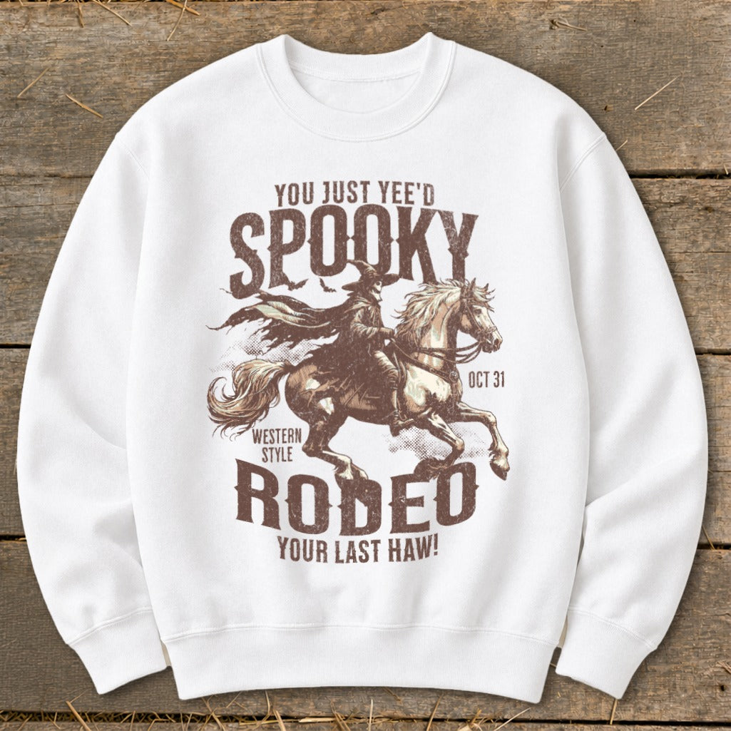 White sweatshirt with spooky cowboy riding a horse and "Spooky Rodeo" text.