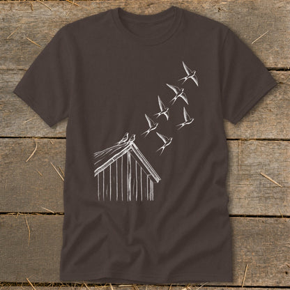 Brown crewneck t-shirt featuring a white line drawing of a barn with birds flying upward.