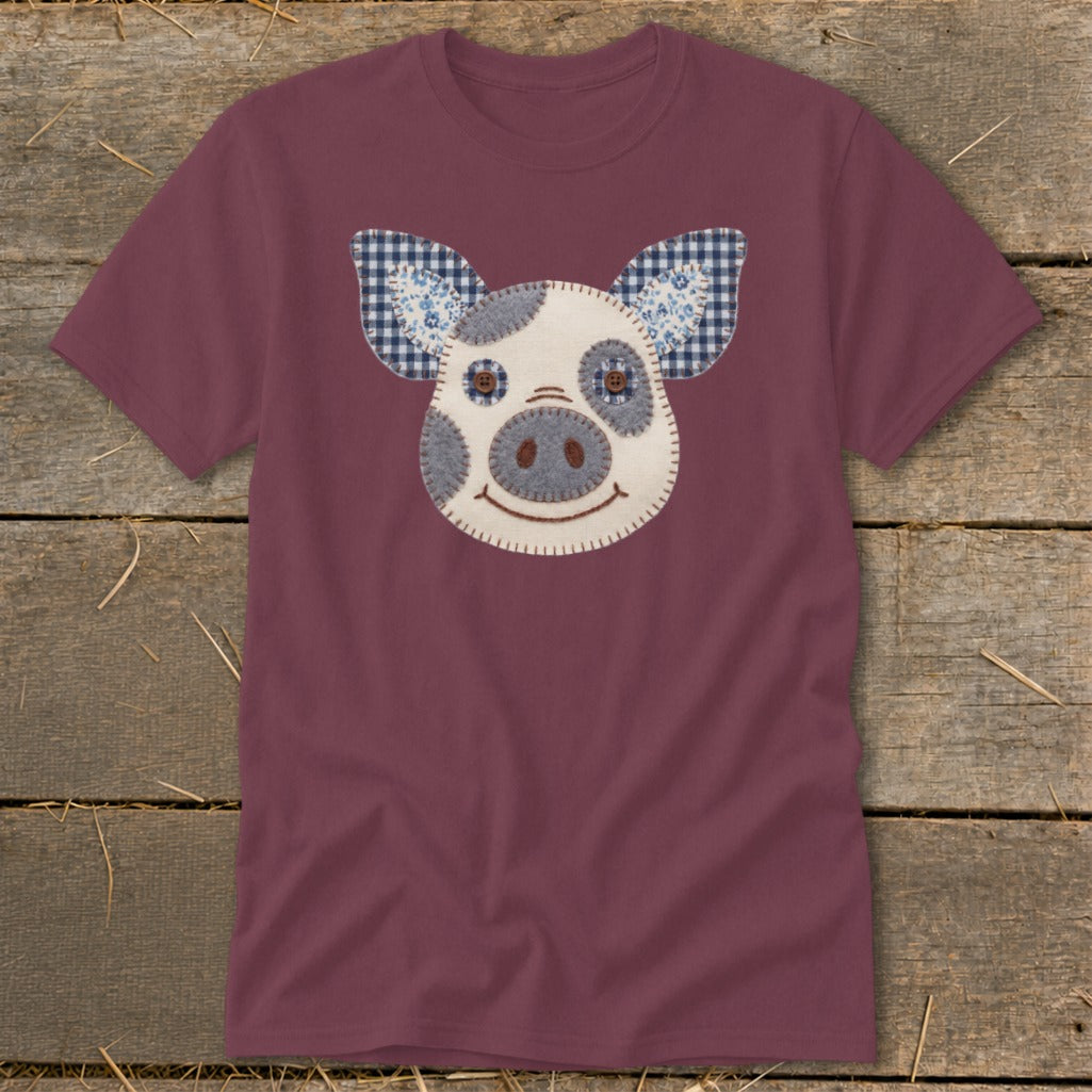 Burgundy t-shirt with a stitched pig face applique featuring plaid ears.