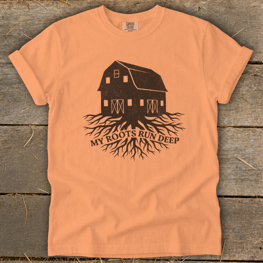 Peach t-shirt with barn and roots graphic, reads "MY ROOTS RUN DEEP".