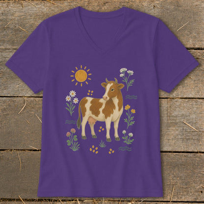 Purple v-neck t-shirt with brown and white cow, sun, and flowers graphic.