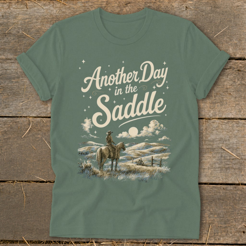 Green t-shirt with "Another Day in the Saddle" text over a cowboy on horseback.