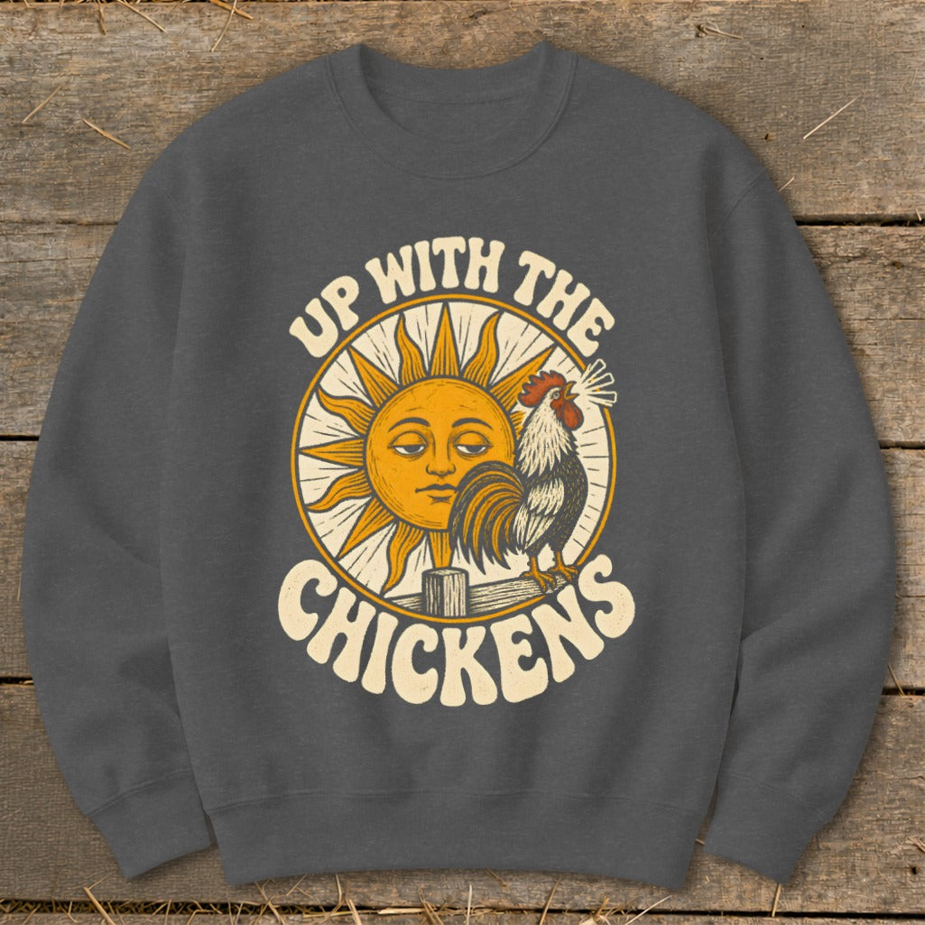 Charcoal crewneck sweatshirt featuring a graphic of a rooster crowing beside a smiling sun and the text "Up With The Chickens".