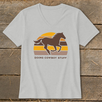Gray v-neck t-shirt with a brown horse silhouette over a striped sunset and "DOING COWBOY STUFF" text.