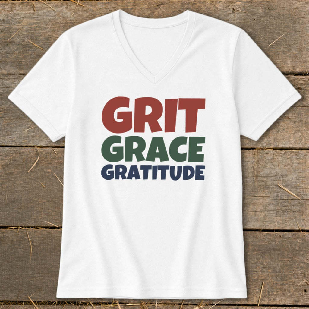 A white V-neck t-shirt with the words Grit, Grace, and Gratitude printed on the chest.