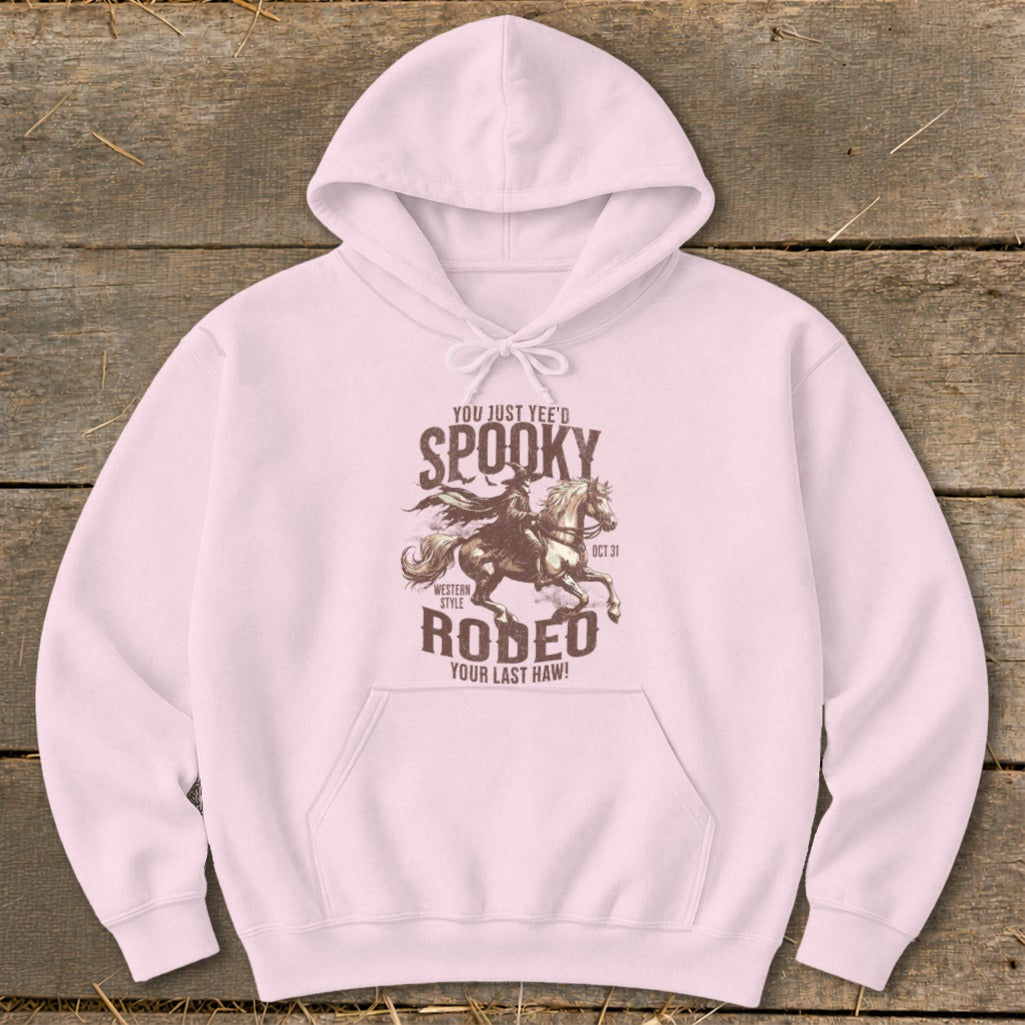 Pink hoodie with a "Spooky Rodeo" graphic featuring a cowboy on horseback.
