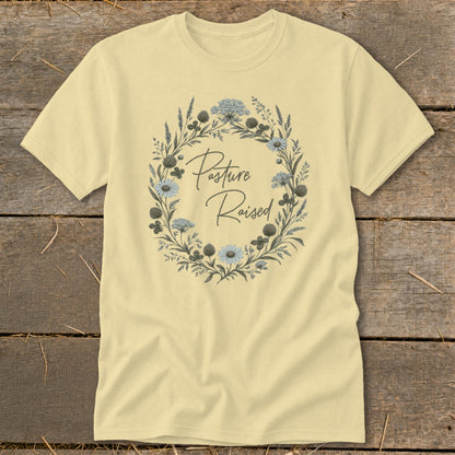 Pale yellow t-shirt with a floral wreath graphic and "Pasture Raised" text.