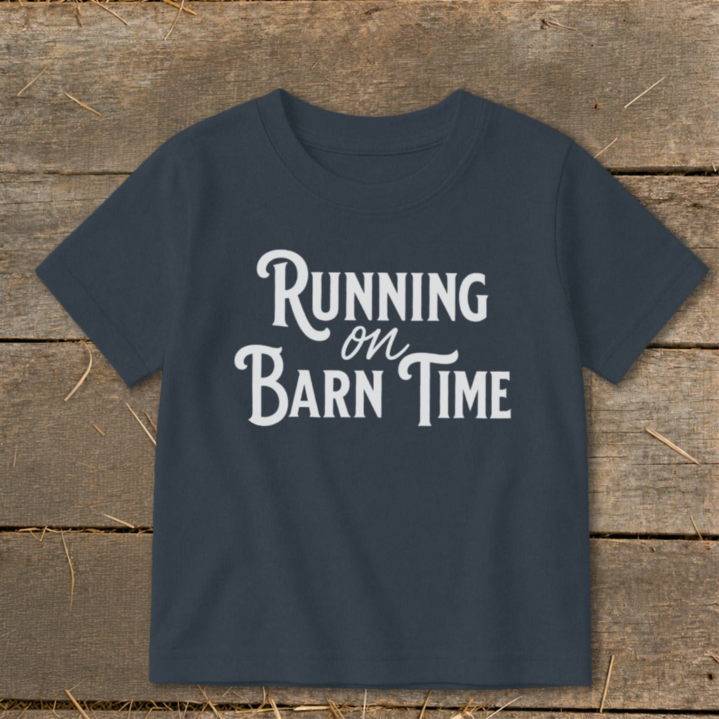 Navy t-shirt with white text "Running on Barn Time" on a wooden background.