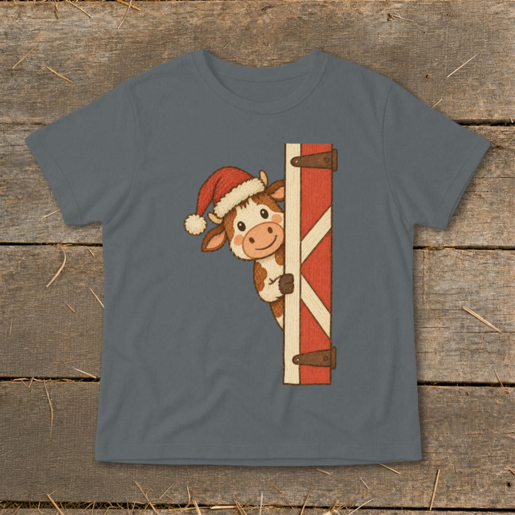 Cartoon cow wearing a Santa hat peeking around a barn door.