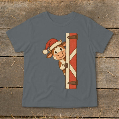 Cartoon cow wearing a Santa hat peeking around a barn door.