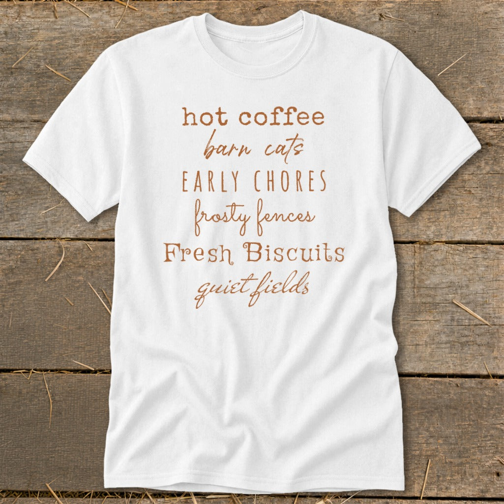 White t-shirt with brown text listing: hot coffee, barn cats, early chores, frosty fences, fresh biscuits, quiet fields.