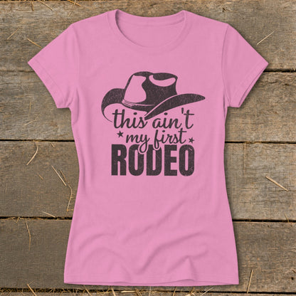 Pink t-shirt with a cowboy hat graphic and text reading "this ain't my first RODEO".