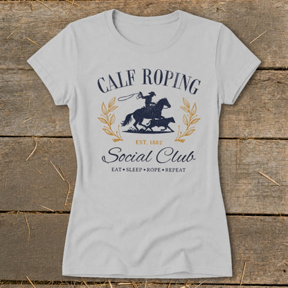 Calf Roping Social Club graphic on light grey t-shirt with cowboy on horse roping calf.