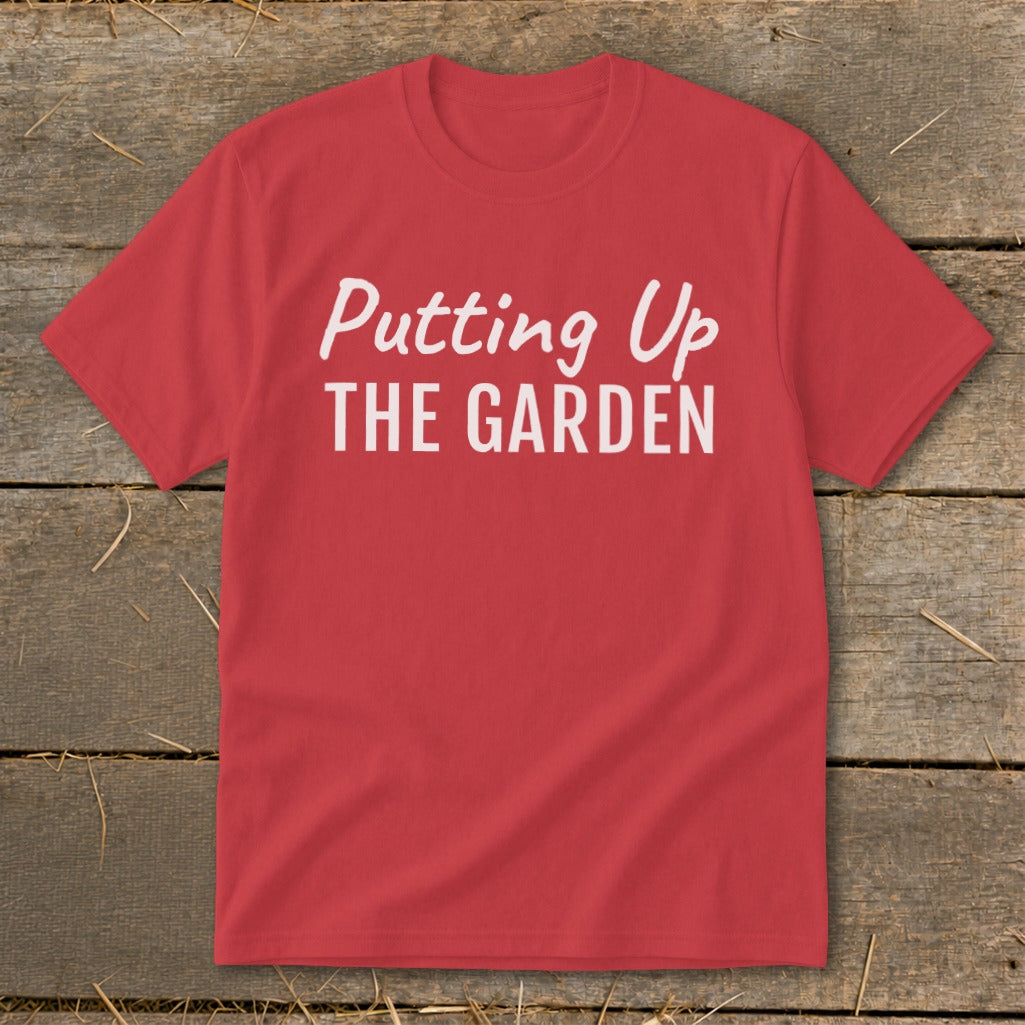 Red t-shirt with white text reading "Putting Up THE GARDEN".