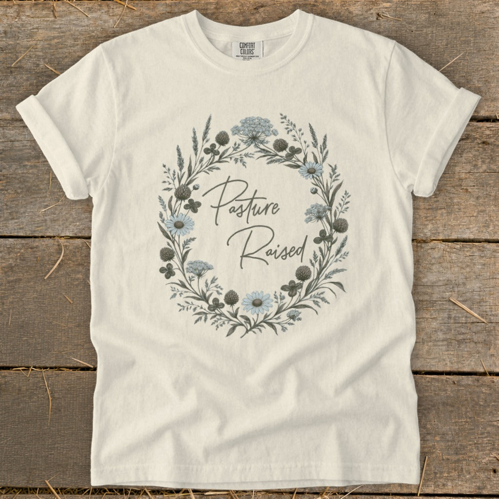 Cream t-shirt with floral wreath graphic and "Pasture Raised" text.