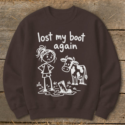 Brown crewneck sweatshirt printed with a funny stick figure graphic and the text lost my boot again.
