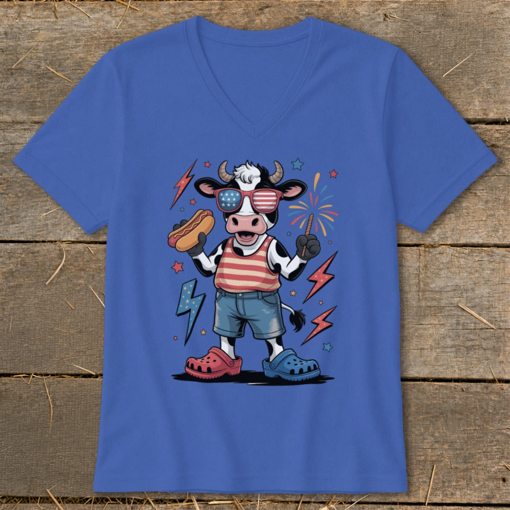 Cartoon cow wearing American flag sunglasses, holding hot dog and sparkler, with fireworks.