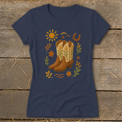 Navy t-shirt with a graphic featuring cowboy boots, sun, horseshoe, and floral elements.