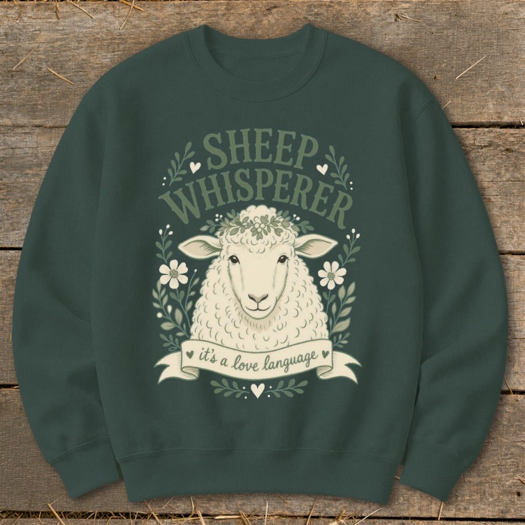 Dark green sweatshirt with a sheep wearing a flower crown, surrounded by leaves and flowers, and text.
