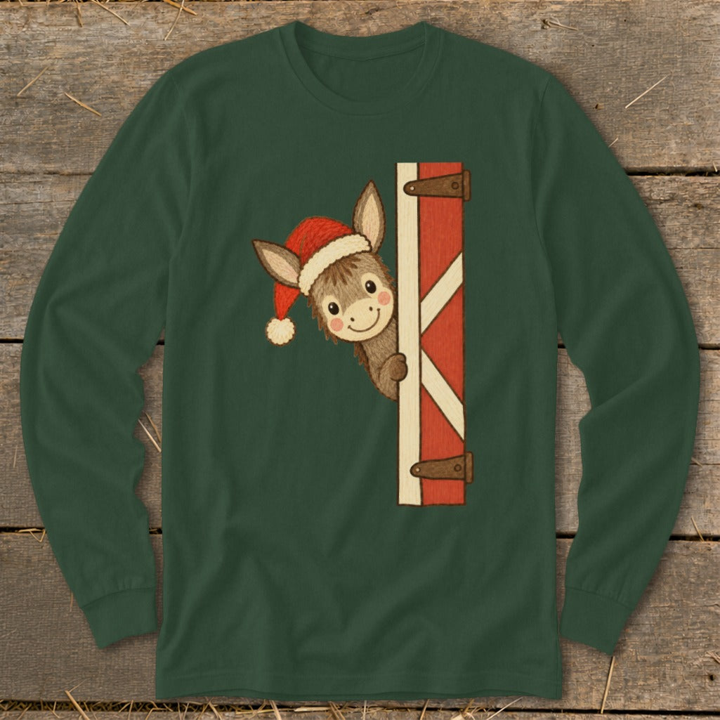 Cute donkey wearing a Santa hat peeking from behind a red barn door.