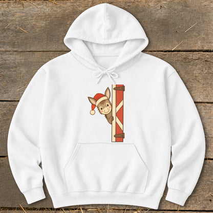 White hoodie with a Christmas donkey peeking from behind a barn door graphic.