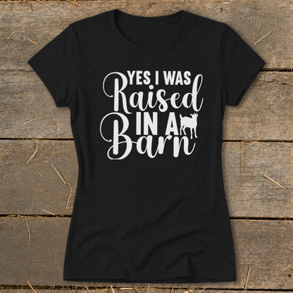 Black t-shirt with white text reading "YES I WAS Raised IN A Barn" and a goat silhouette.