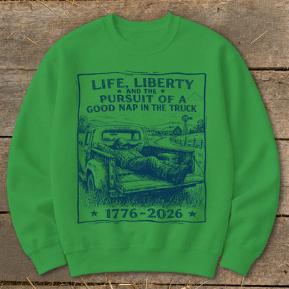 Green sweatshirt with "Life, Liberty, Pursuit of a Good Nap in the Truck" text and illustration.
