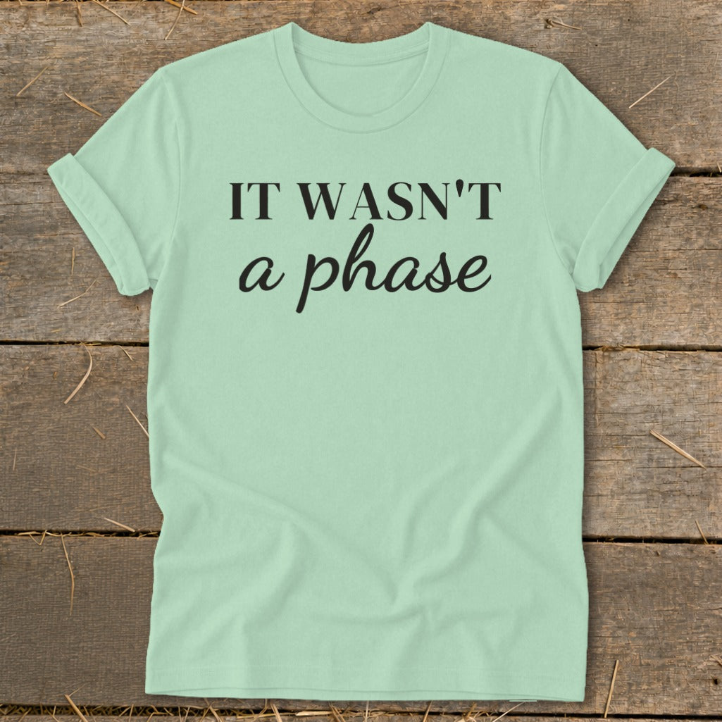 Light green t-shirt with black text "IT WASN'T a phase".