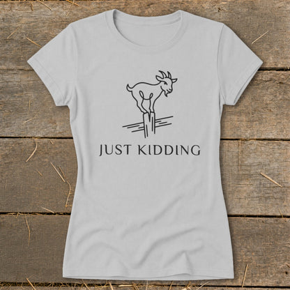 Light gray t-shirt with a minimalist goat balancing on a post, text reads "JUST KIDDING."