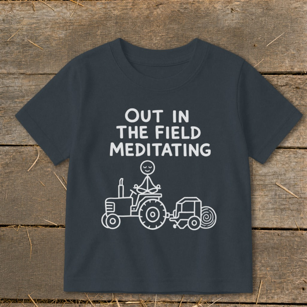 Dark gray t-shirt with white text and illustration of stick figure meditating on a tractor.
