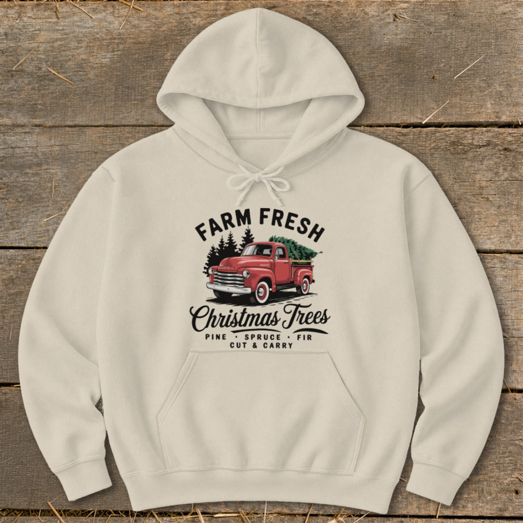 Cream hoodie with "Farm Fresh Christmas Trees" graphic featuring a red truck hauling a tree.